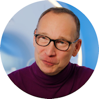 un hombre con gafas y un jersey de cuello alto morado