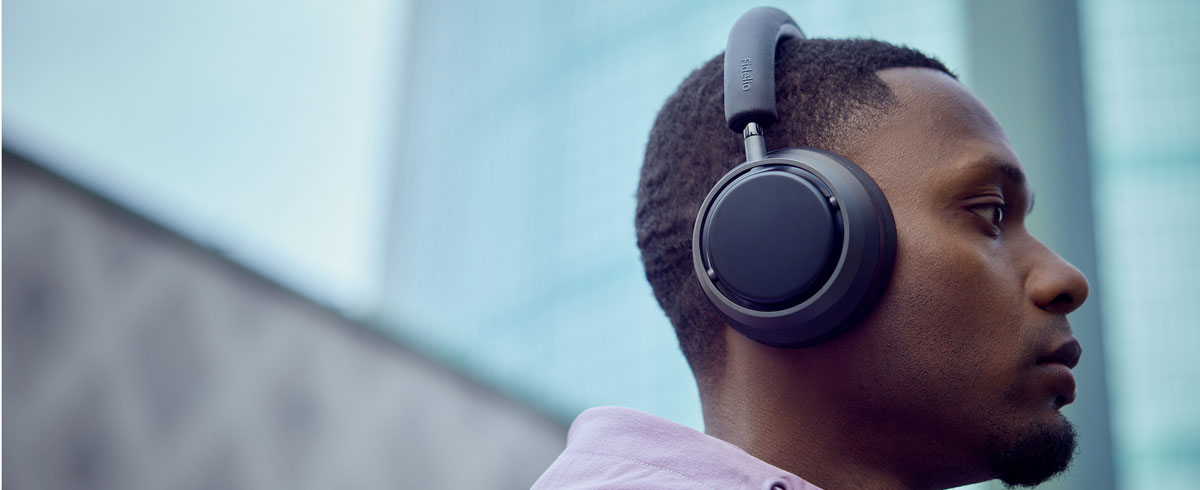 Un hombre escuchando m&uacute;sica con unos auriculares Philips X3.