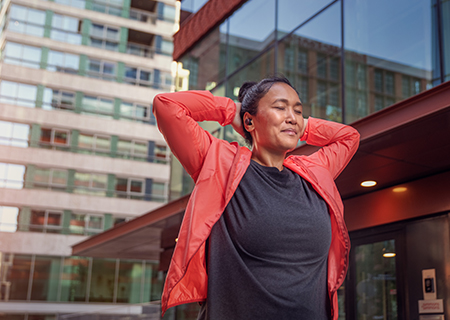 Mujer usando auriculares inal&aacute;mbricos Philips A5508 al aire libre