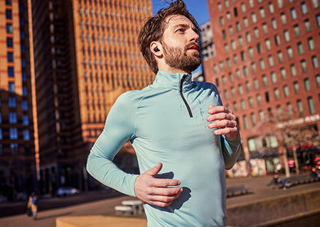 Hombre corriendo al aire libre escuchando m&uacute;sica a trav&eacute;s de auriculares inal&aacute;mbricos verdaderos Philips A5508